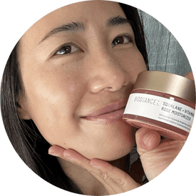 @jasmine.aeiou, a young woman with dark hair, smiling and holding jar of biossance squalane + vitamin c rose moisturizer